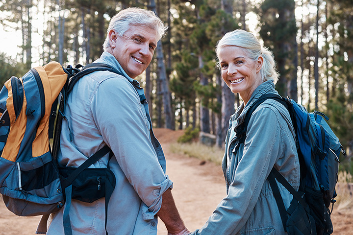 Älteres Paar beim Wandern im Wald mit grünem Star